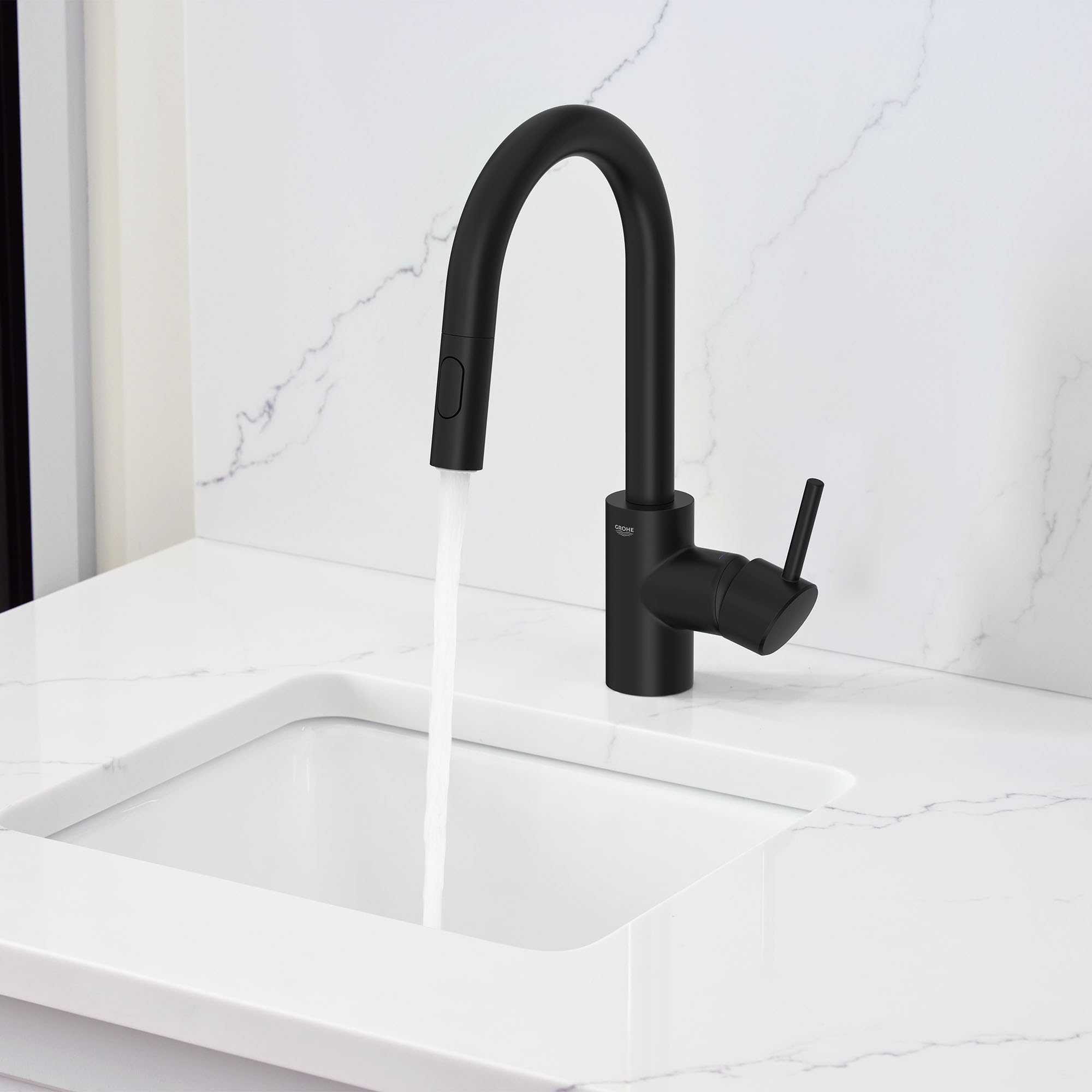 Matte black single-handle pull-down bar faucet with curved spout installed on white marble countertop.