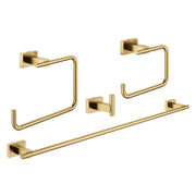 Four brushed gold bathroom accessories including two towel rings, one towel hook, and one towel bar with square mounting plat