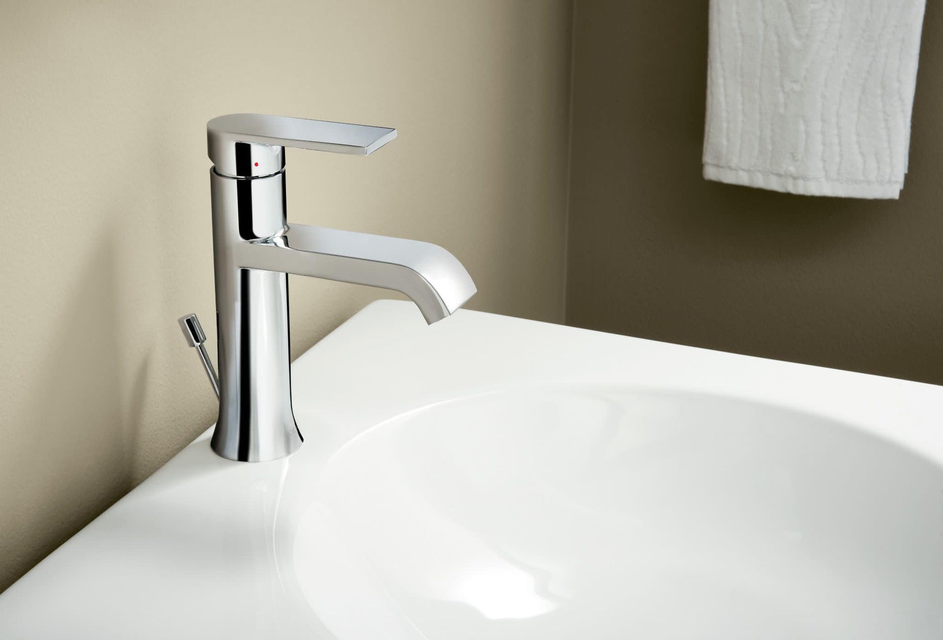 Chrome single-handle bathroom faucet with curved spout mounted on white sink basin.
