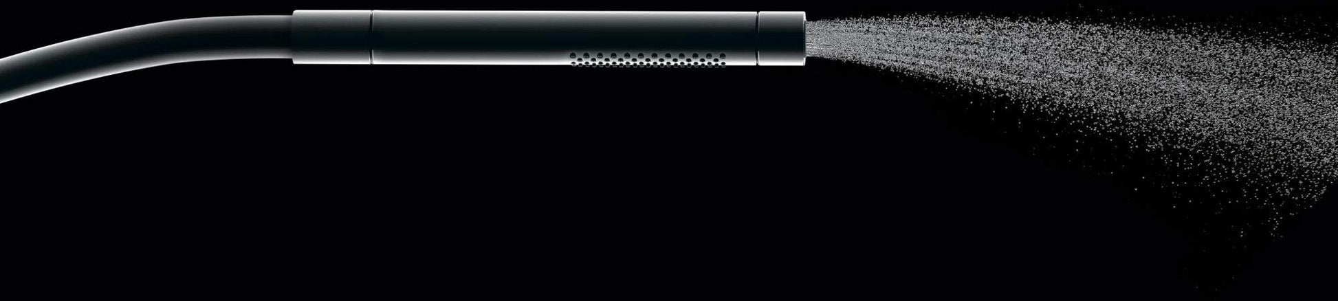 Brushed nickel handheld showerhead with cylindrical grip spraying water mist against black background.