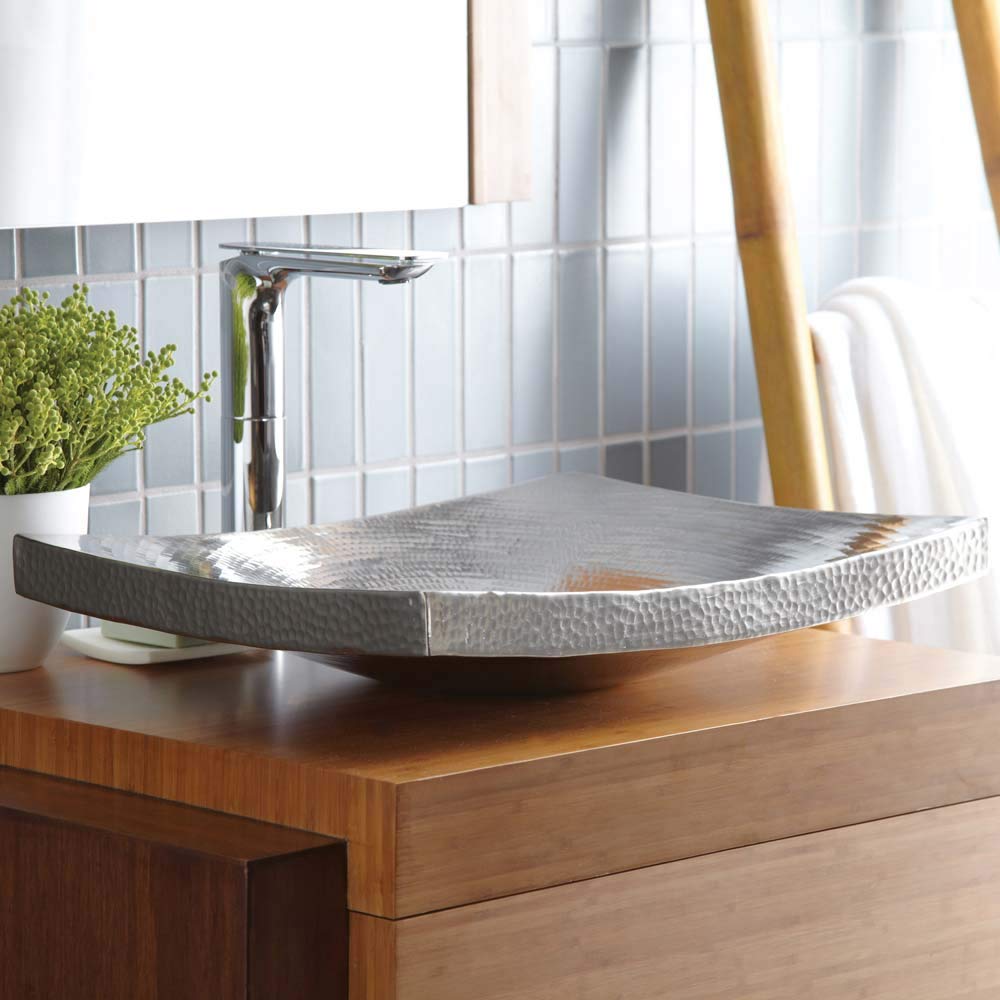 Brushed nickel vessel sink with hammered texture and curved rim, displayed on wooden vanity with tall faucet.