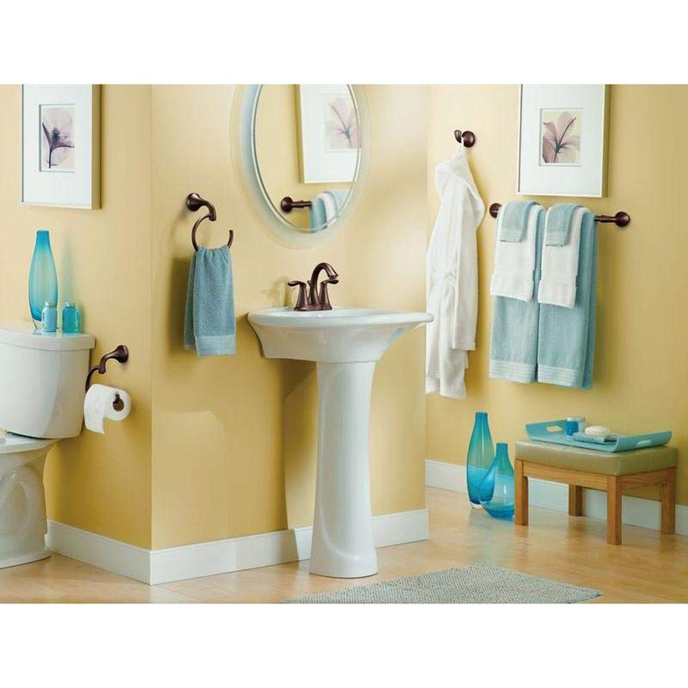Oil rubbed bronze towel bar mounted on yellow bathroom wall holding folded towels.