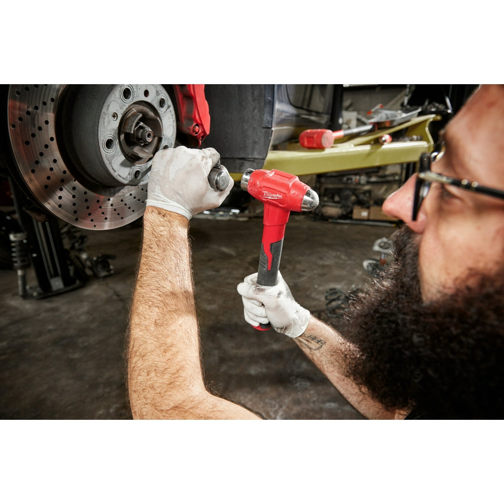 Red and black dead blow hammer with ball peen head held in worker's hand near brake disc.