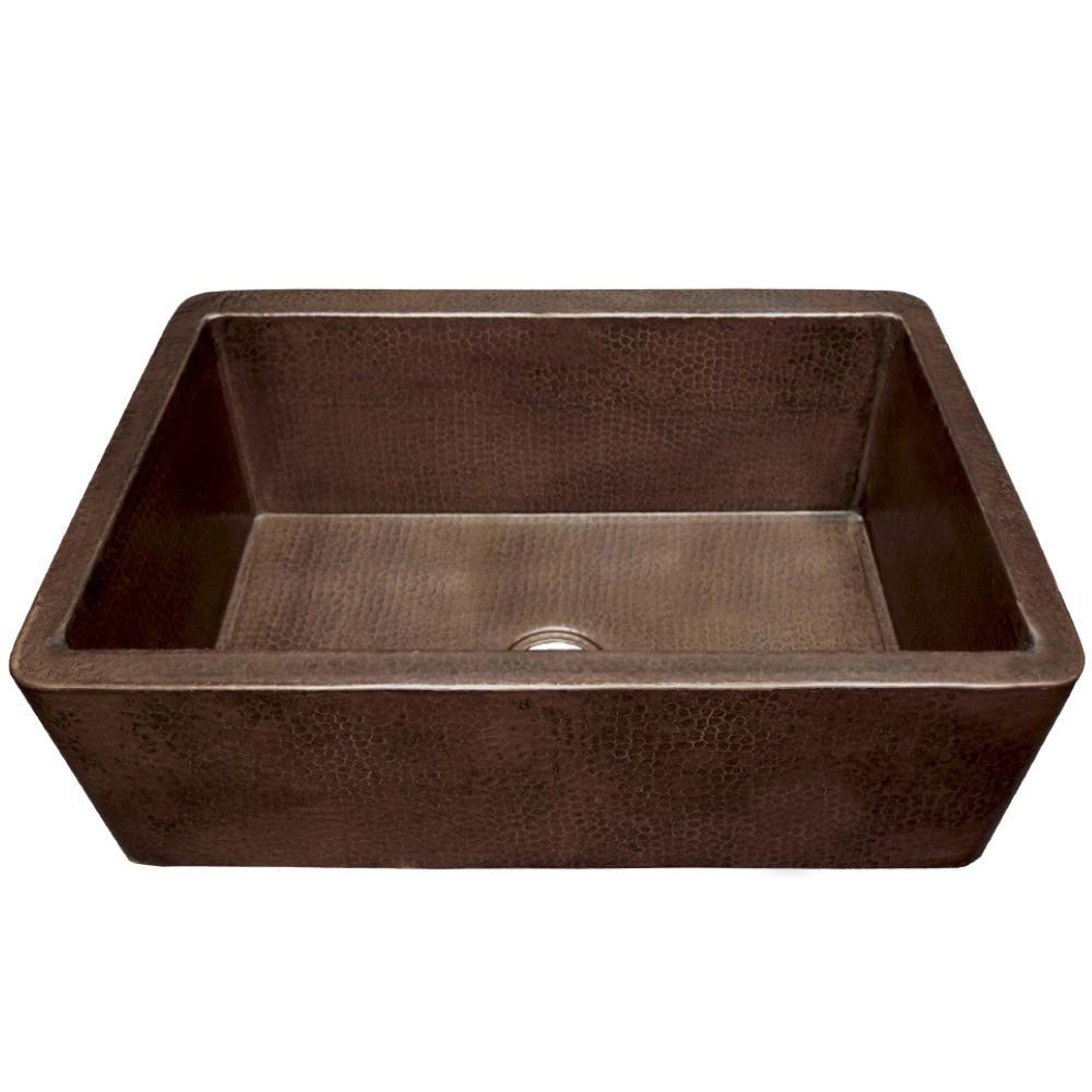 Antique copper farmhouse sink with single basin and textured hammered surface finish.