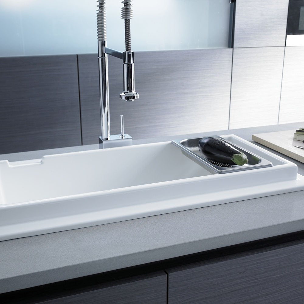 Chrome kitchen faucet with pull-down dual spray head mounted above white undermount sink.