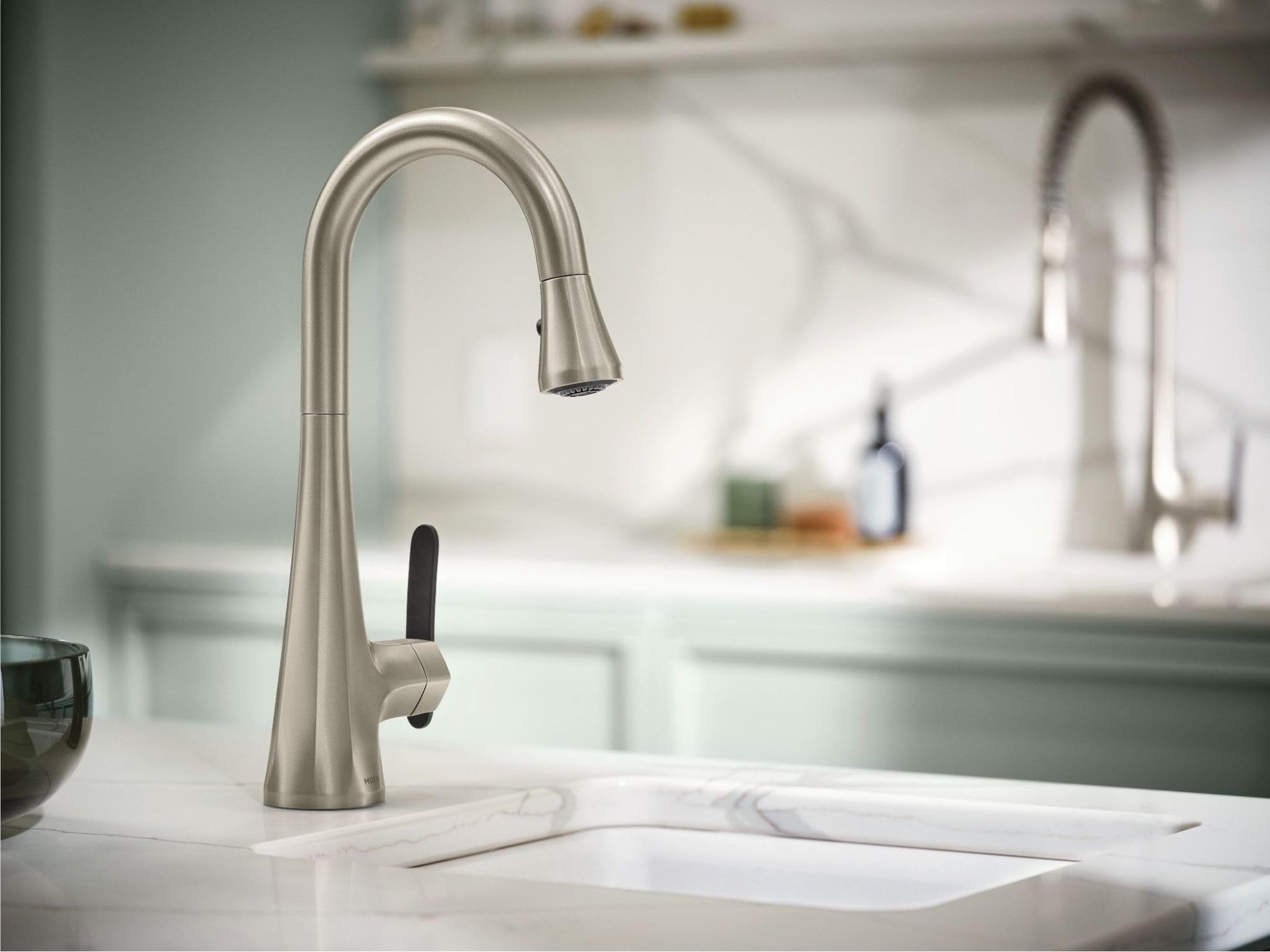 Stainless steel kitchen faucet with high arc spout and pulldown spray head mounted on white countertop.