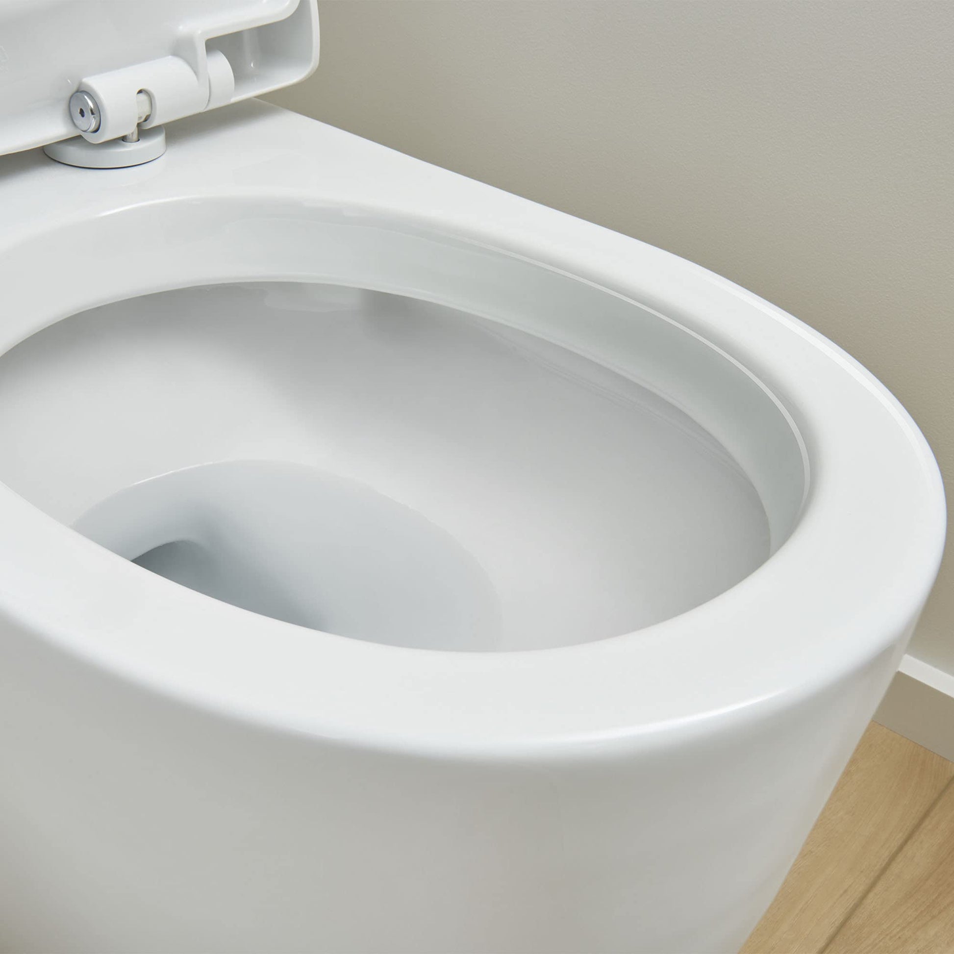 White elongated toilet bowl with attached seat and left-side trip lever mechanism visible.