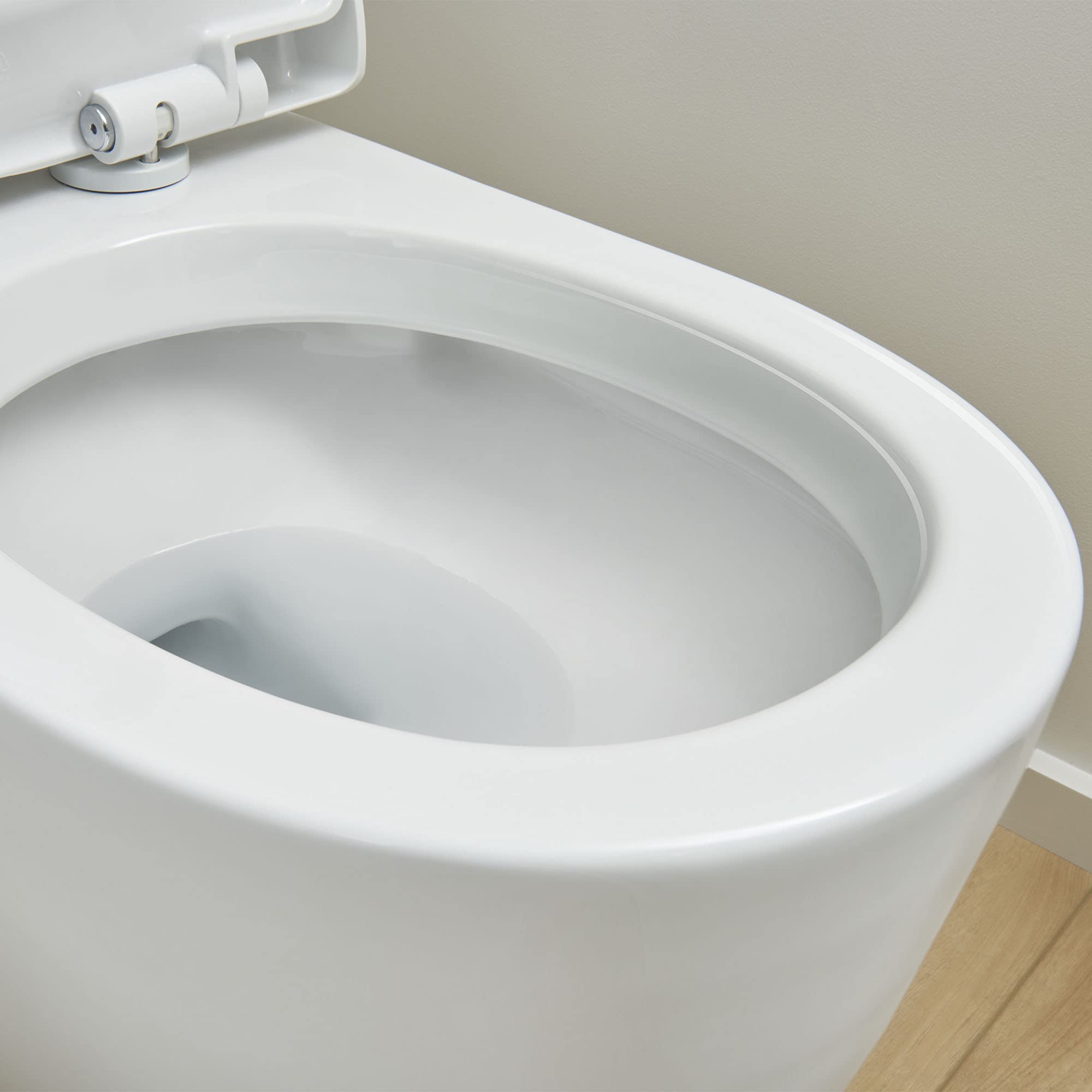 White elongated toilet bowl with attached seat and left-side trip lever mechanism visible.