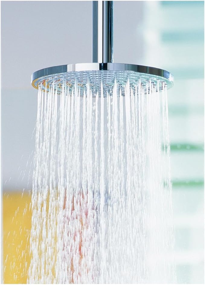Chrome circular shower head with multiple jets dispensing water in a rain-like pattern against a blurred background.