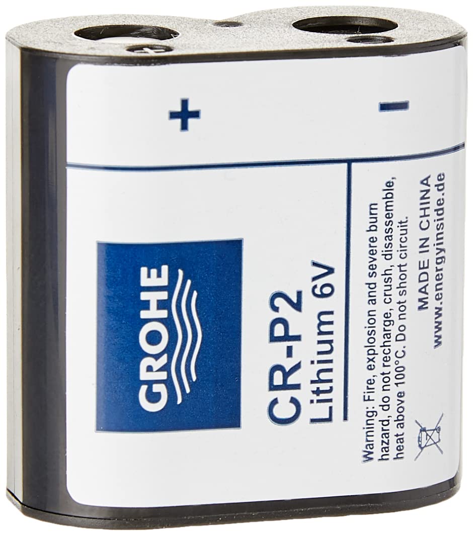 Grohe CR-P2 lithium 6V battery with chrome metal casing and blue label marking positive and negative terminals.