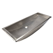 Rectangular brushed nickel trough sink with hammered texture finish and single drain hole.