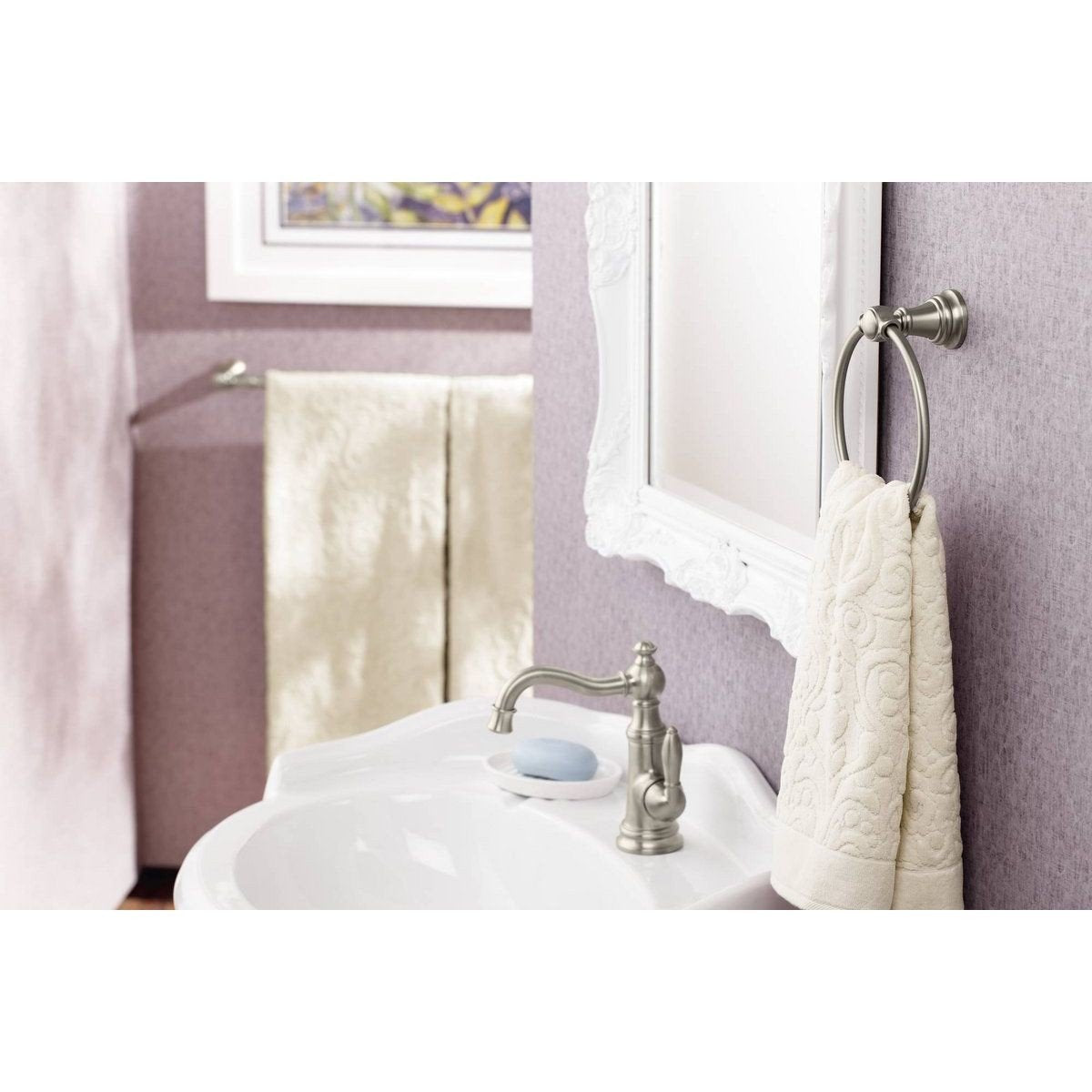 Chrome single-handle bathroom sink faucet with curved spout installed on white round sink.