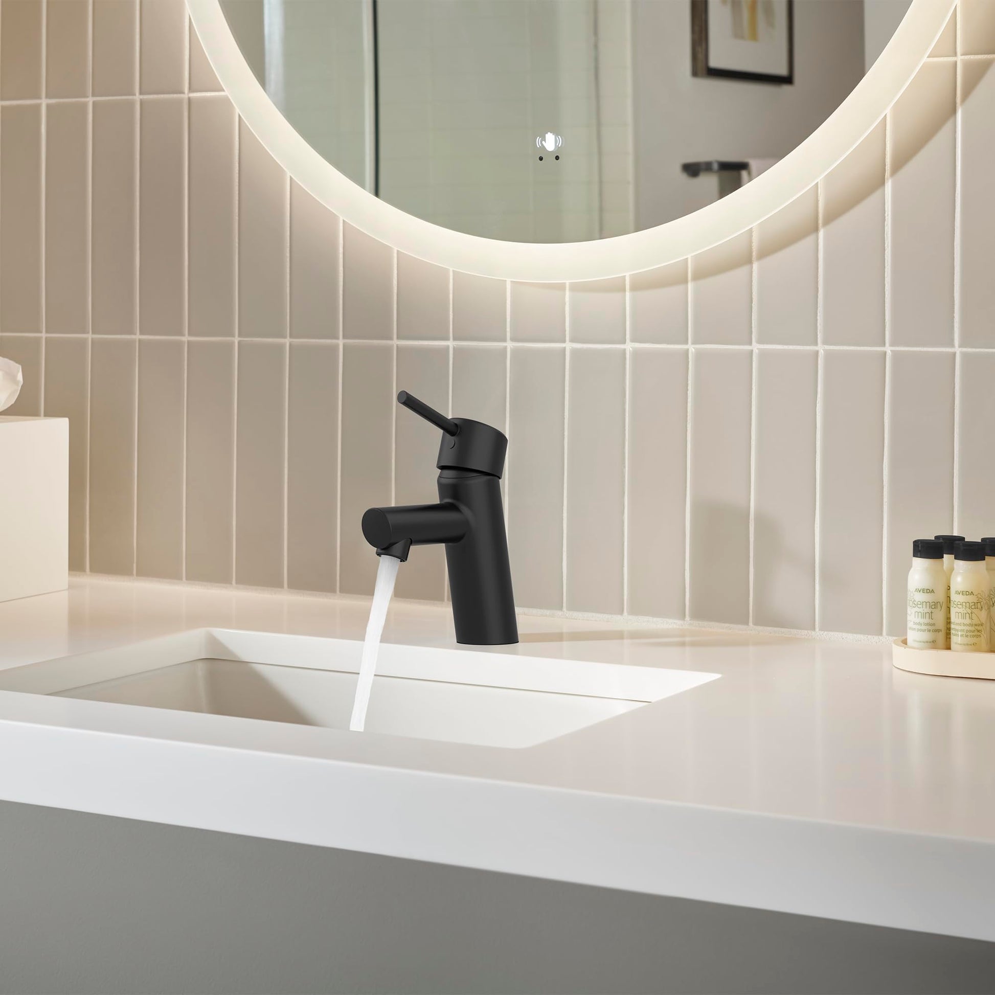 Matte black single-handle bathroom faucet with curved spout installed on white sink countertop.