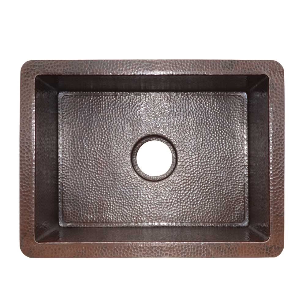 Antique copper kitchen sink with hammered texture finish and single drain hole, viewed from above.