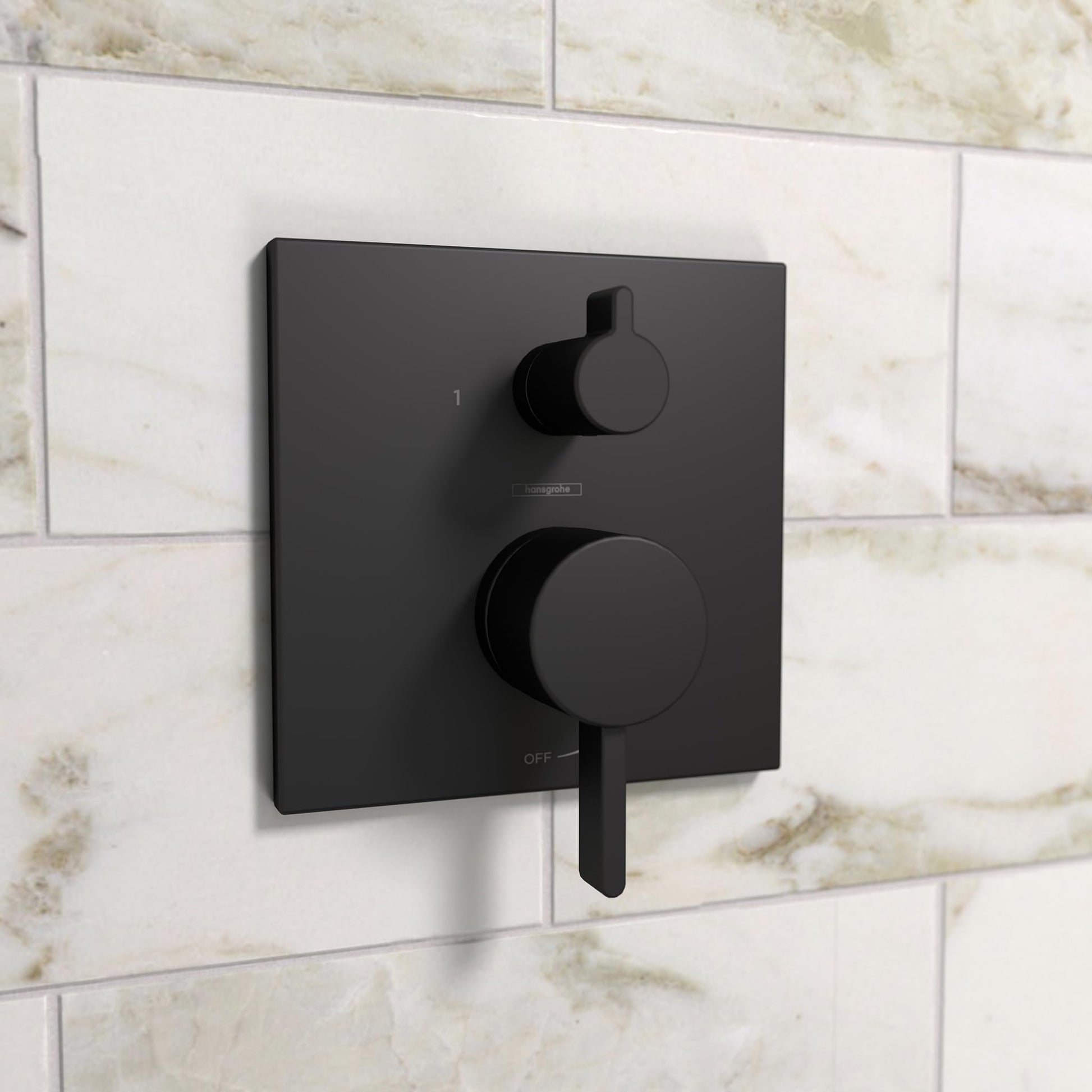 Matte black square shower trim with round diverter lever and upper control knob mounted on tile wall.