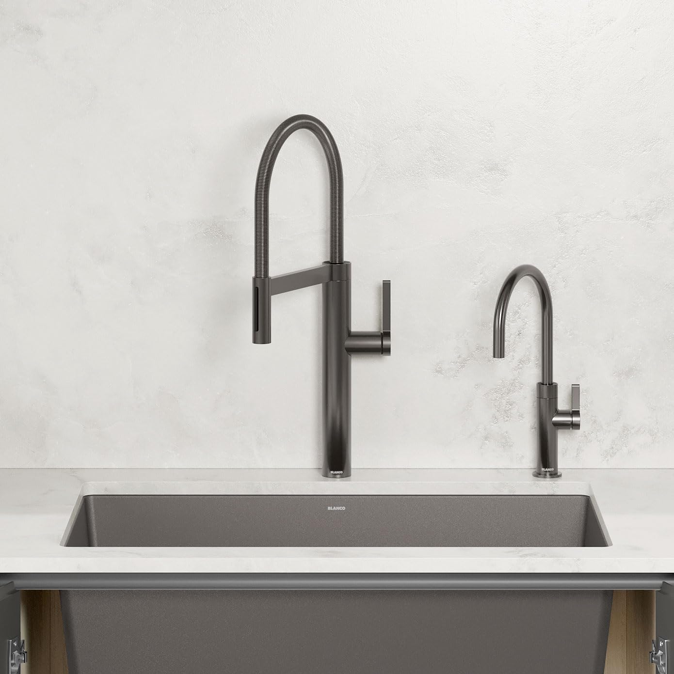 Satin dark steel beverage faucet with curved pull-down spout and smaller secondary spout mounted above rectangular sink basin