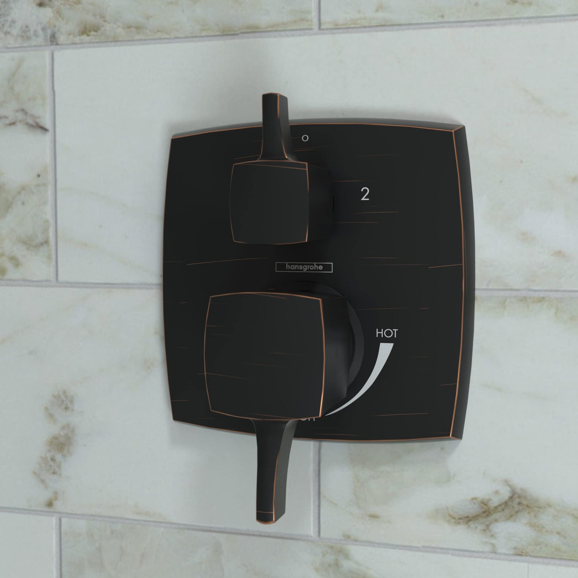 Rubbed bronze square pressure balance shower trim with diverter, featuring two handles and hot water indicator on marble tile
