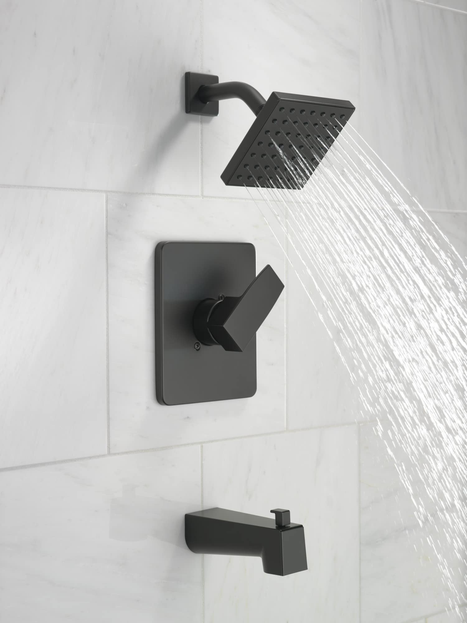 Matte black tub and shower trim kit with square showerhead, curved arm, lever handle, and tub spout mounted on white tile wal