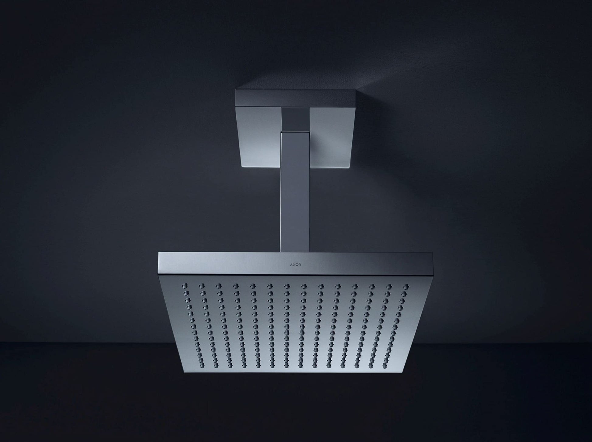 Chrome square shower head with ceiling-mounted arm and perforated spray face.