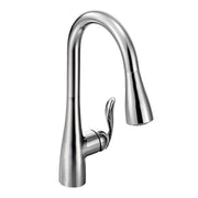 Chrome kitchen faucet with curved spout, single handle, and retractable sprayer head.