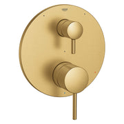 Grohe brushed gold pressure balance valve trim with two round handles and diverter control on circular backplate.