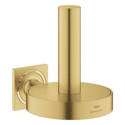 Brushed gold toilet paper holder with cylindrical post mounted on square wall plate.