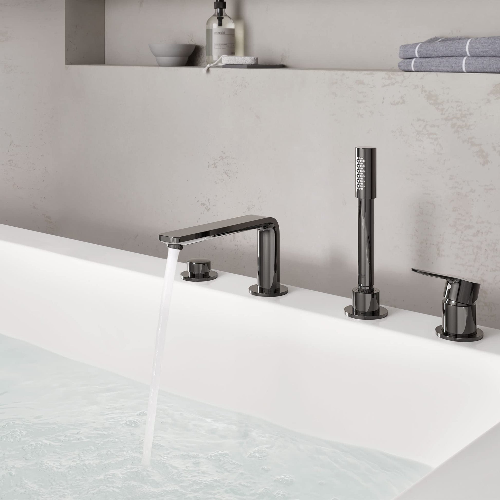Dark graphite deck-mount roman tub faucet with single handle, spout, handheld shower, and control knobs installed on white ba