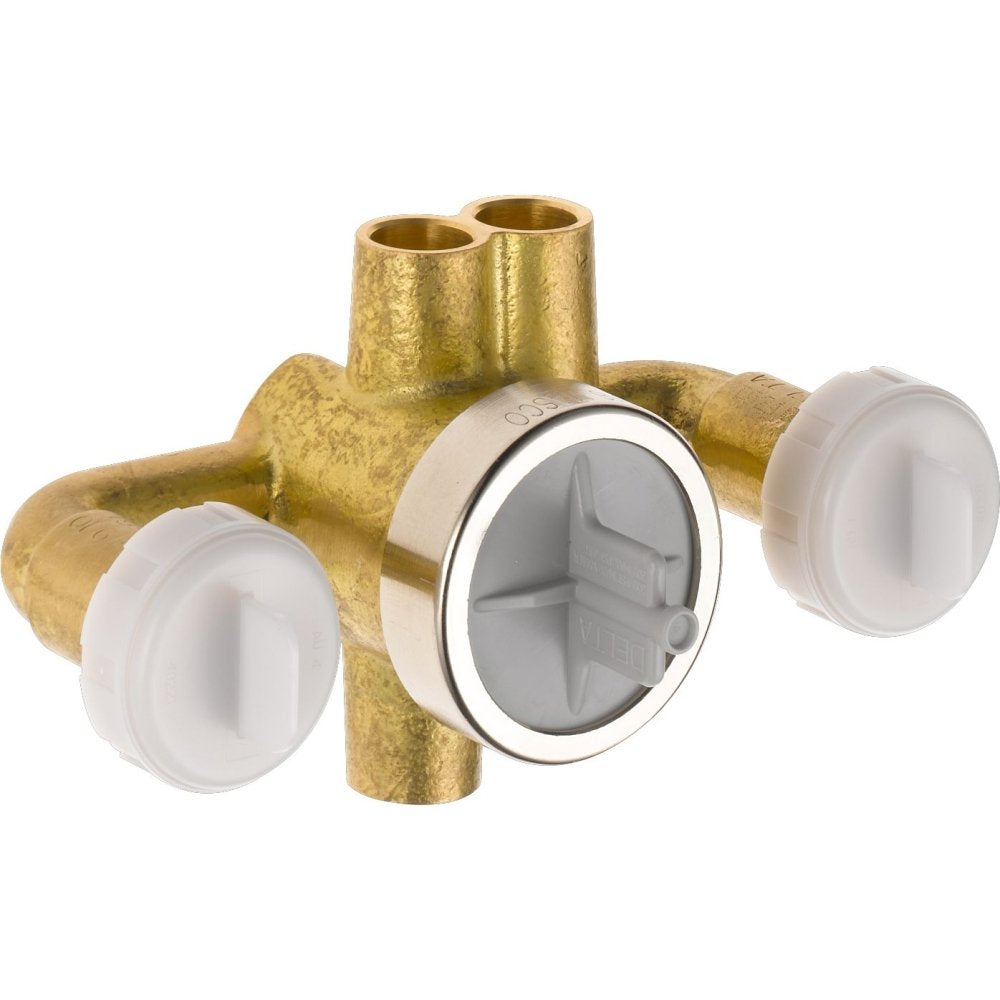 Brass shower diverter valve with white plastic caps and central chrome trim ring, showing internal diverter mechanism.