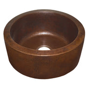 Round hammered copper undermount sink with textured finish and single drain opening.