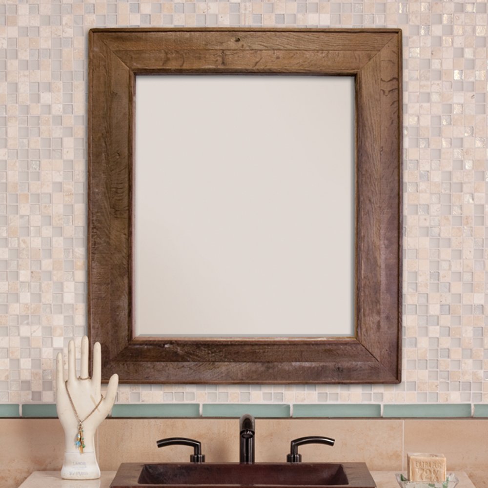 Wooden-framed mirror with dark brown finish mounted above bathroom vanity with mosaic tile backsplash.