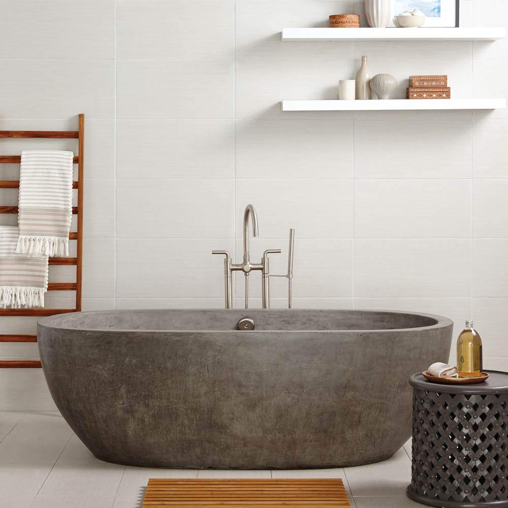 Ash-colored freestanding bathtub with curved oval shape and brushed nickel faucet in modern bathroom setting.