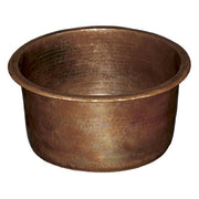 Antique hammered copper bar sink with textured surface and rounded cylindrical basin.