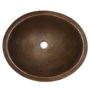 Antique copper round bathroom sink with hammered finish and center drain hole, viewed from above.