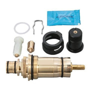 Grohe thermostatic cartridge repair kit with brass cylinder, black components, white seals, metal clip, and blue lubricant pa