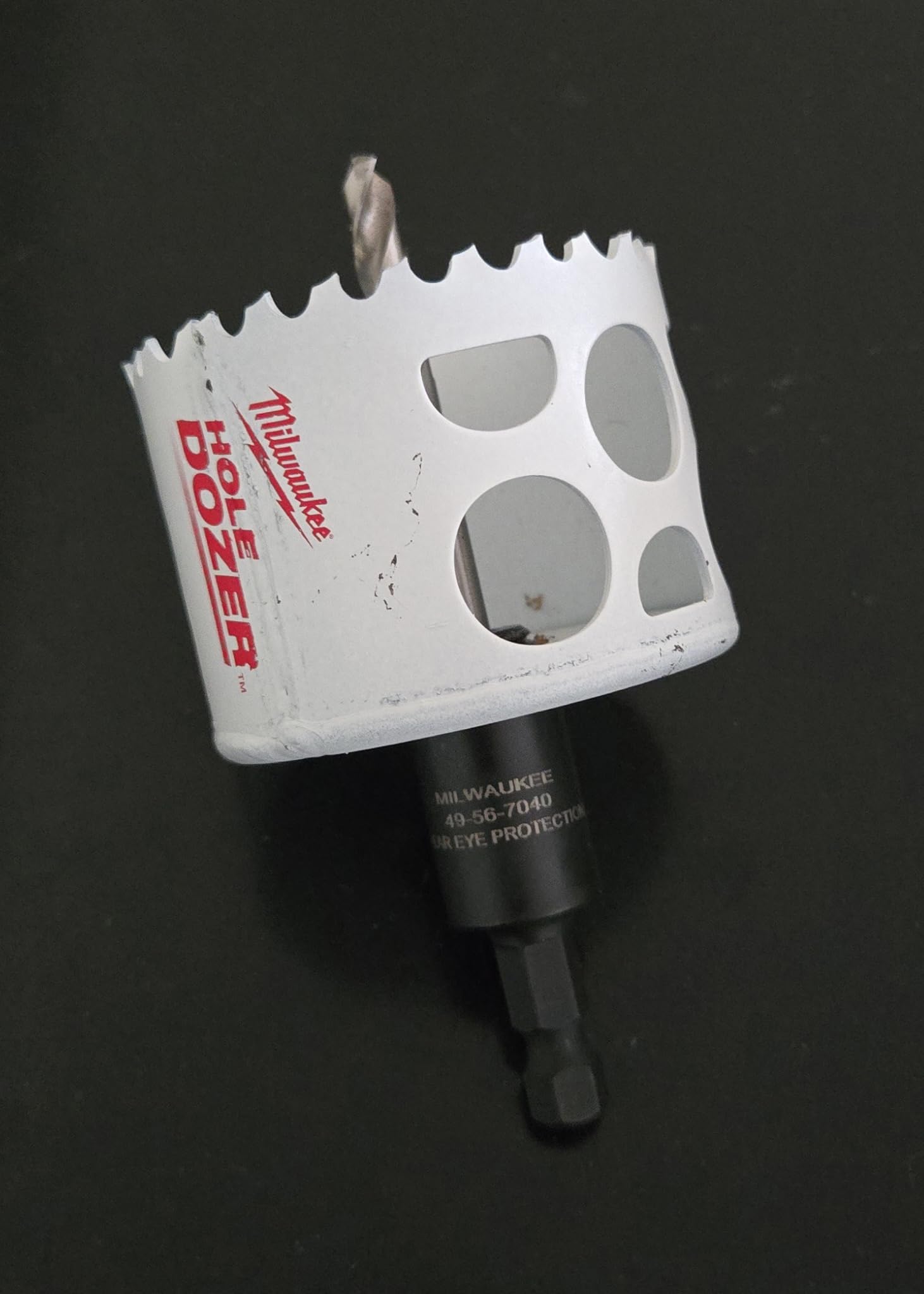Milwaukee HOLE DOZER bi-metal hole saw with serrated edge, arbor shaft, and mounting holes on white cylindrical body.