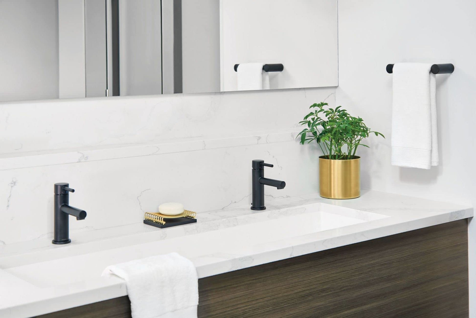 Matte black single-handle bathroom faucet with curved spout installed on white marble vanity countertop.
