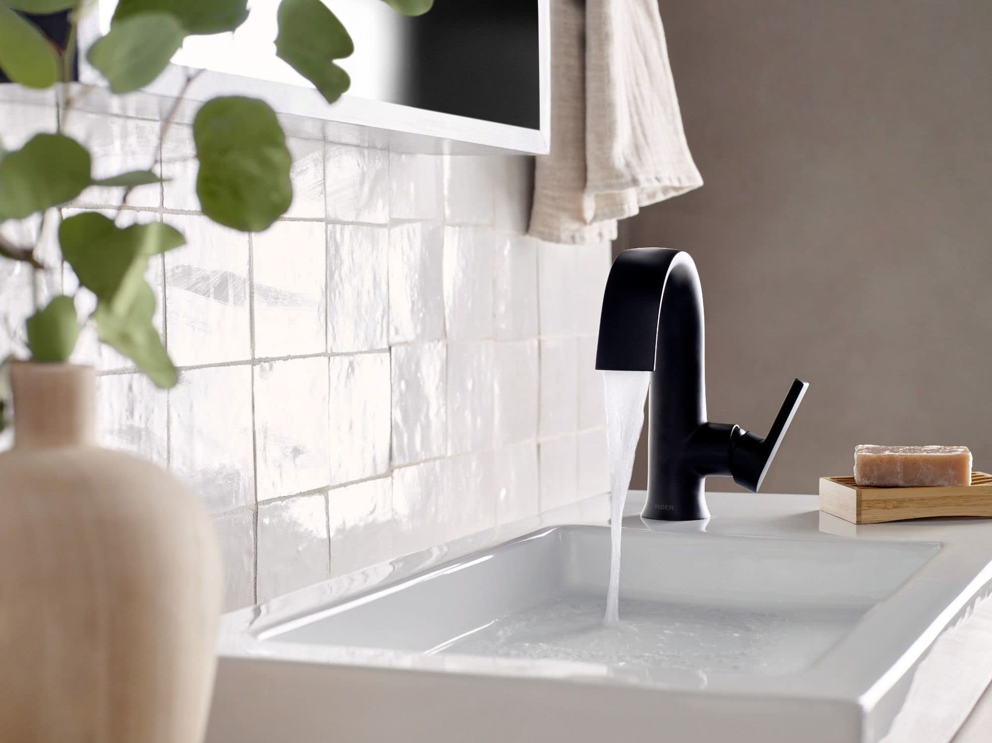 Matte black single-handle bathroom faucet with high arc spout installed on white sink countertop.