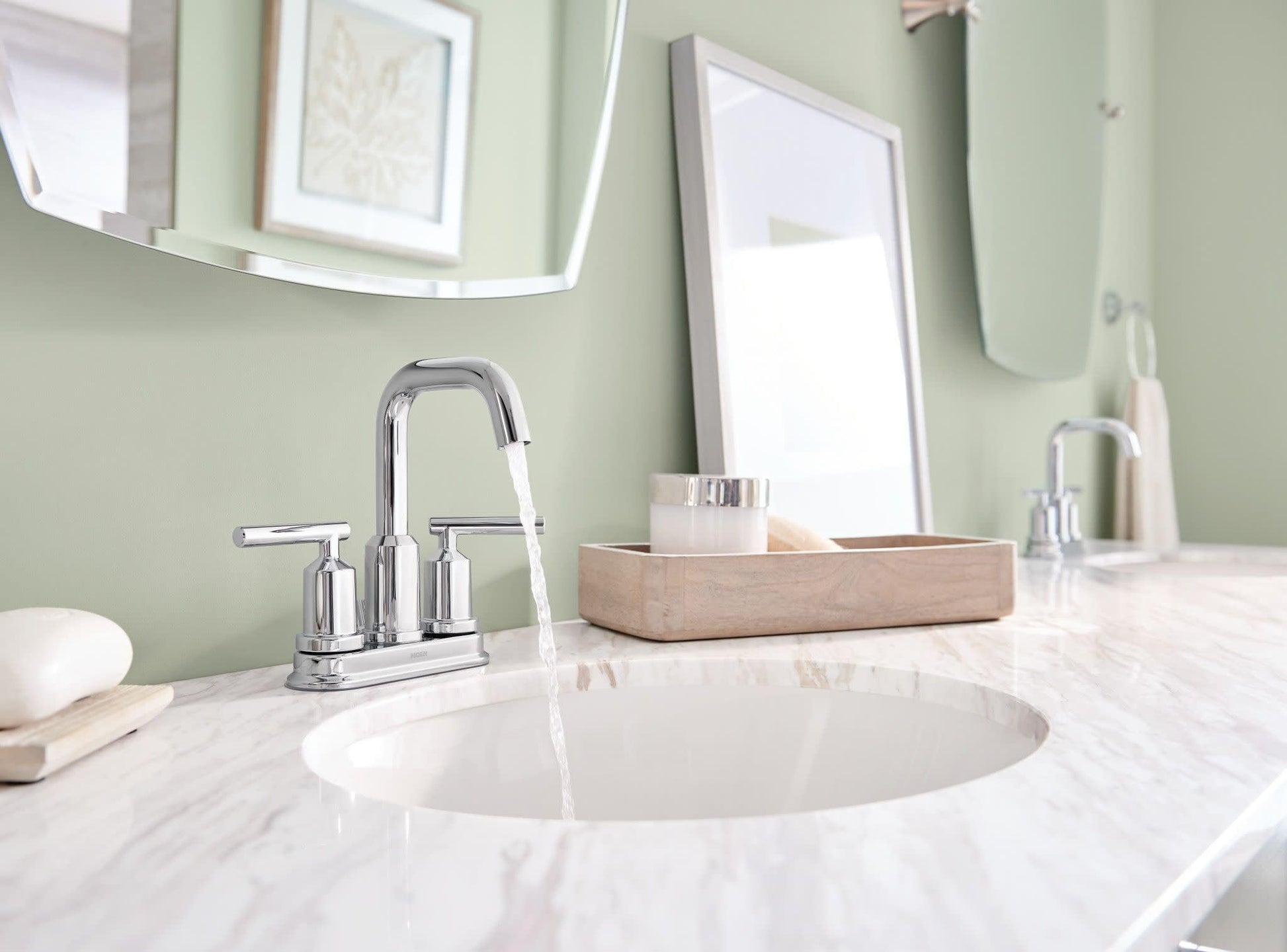 Chrome two-handle centerset bathroom faucet with curved spout installed above round sink basin.