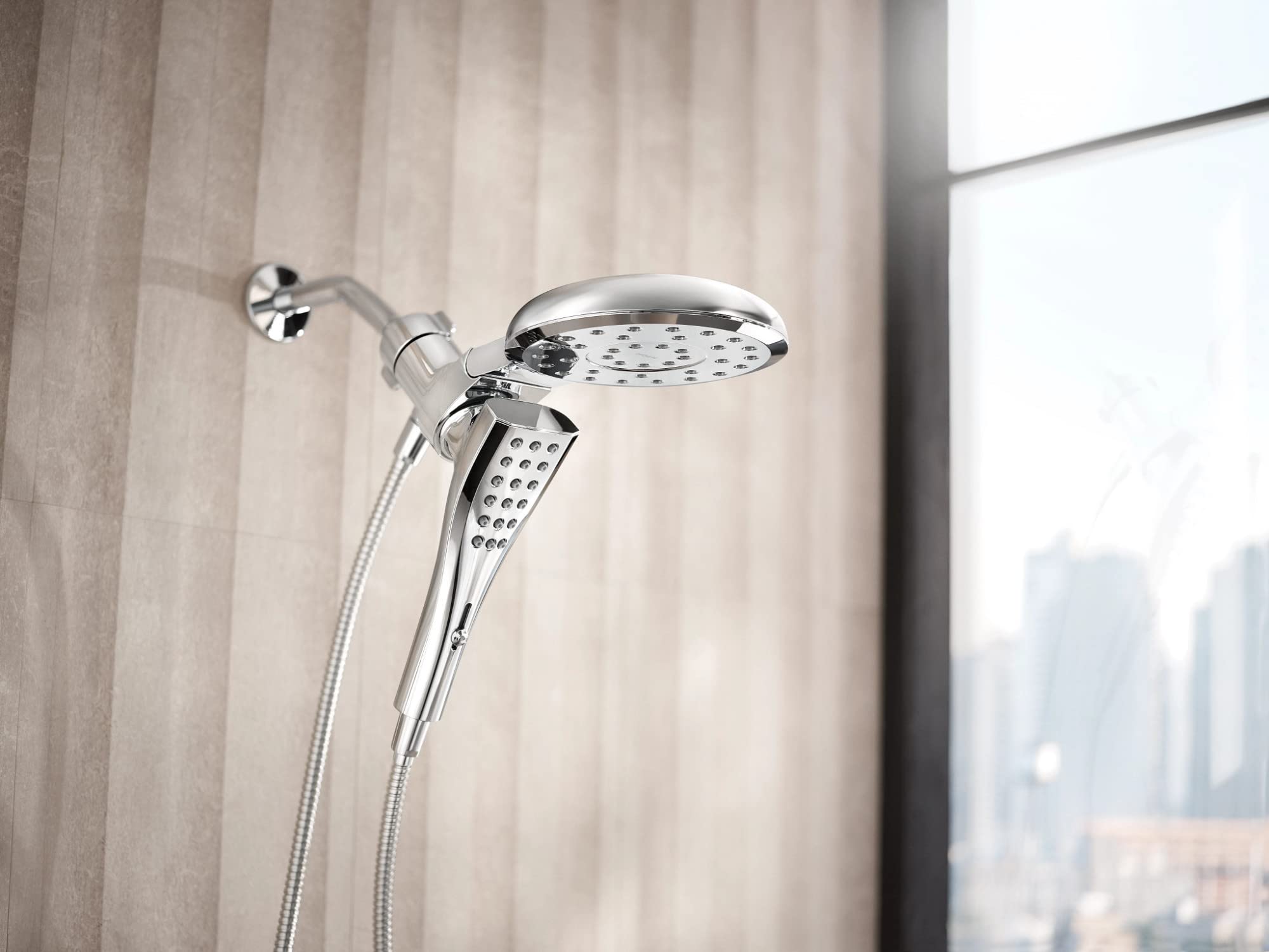 Chrome dual shower head with fixed overhead head and handheld wand on flexible hose mounted to wall.