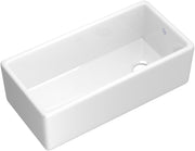 White fireclay farmhouse apron front kitchen sink with single bowl and drain opening.