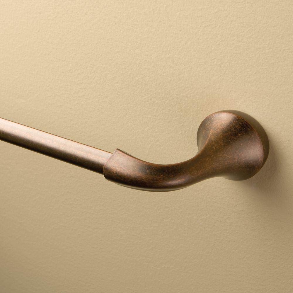 Oil rubbed bronze curved towel bar mounted on beige wall with spherical end cap.