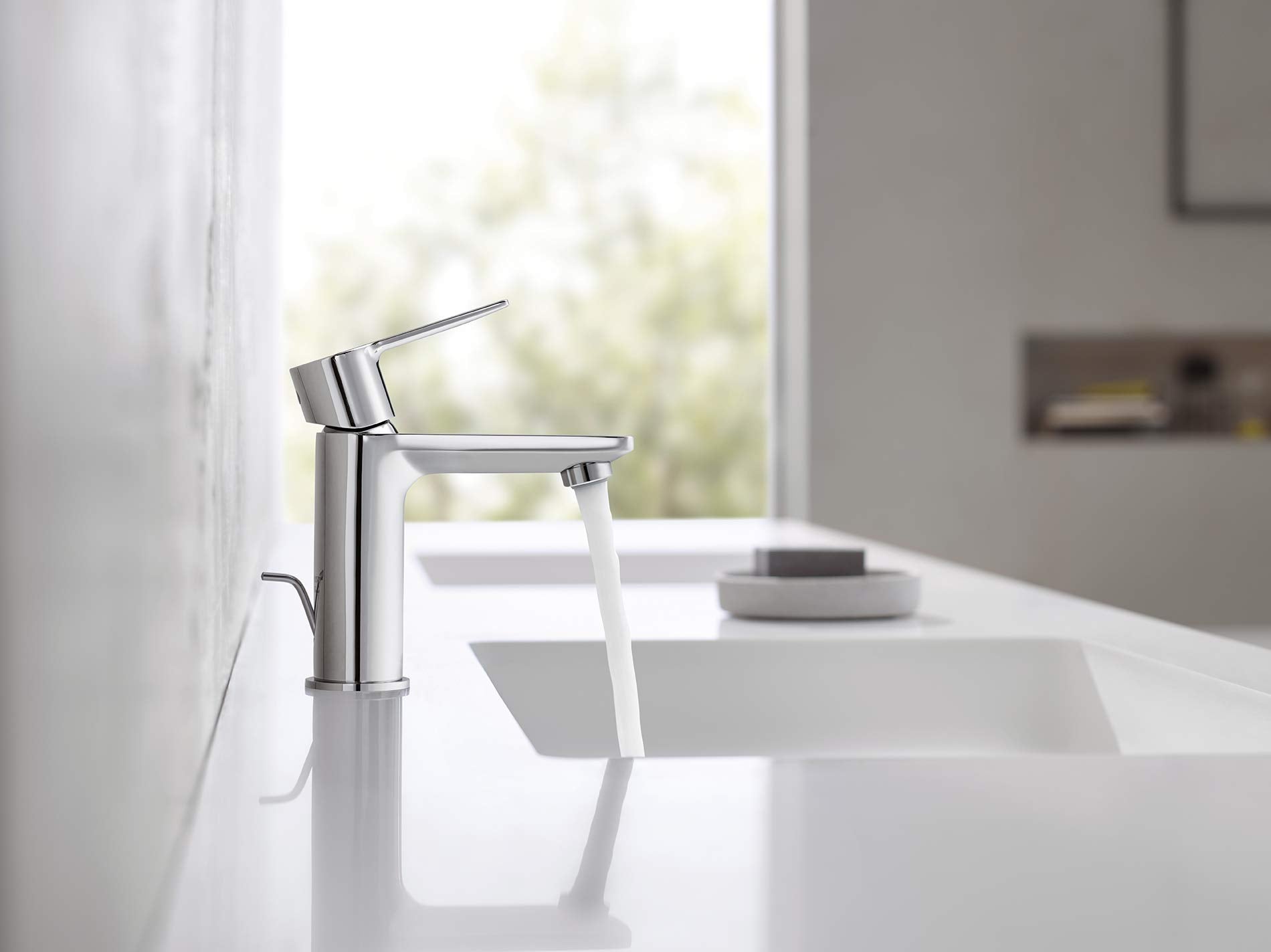 Chrome single-handle bathroom faucet with angled spout mounted on white sink counter.