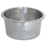 Hammered copper round bar sink with rolled rim and sloped interior basin.