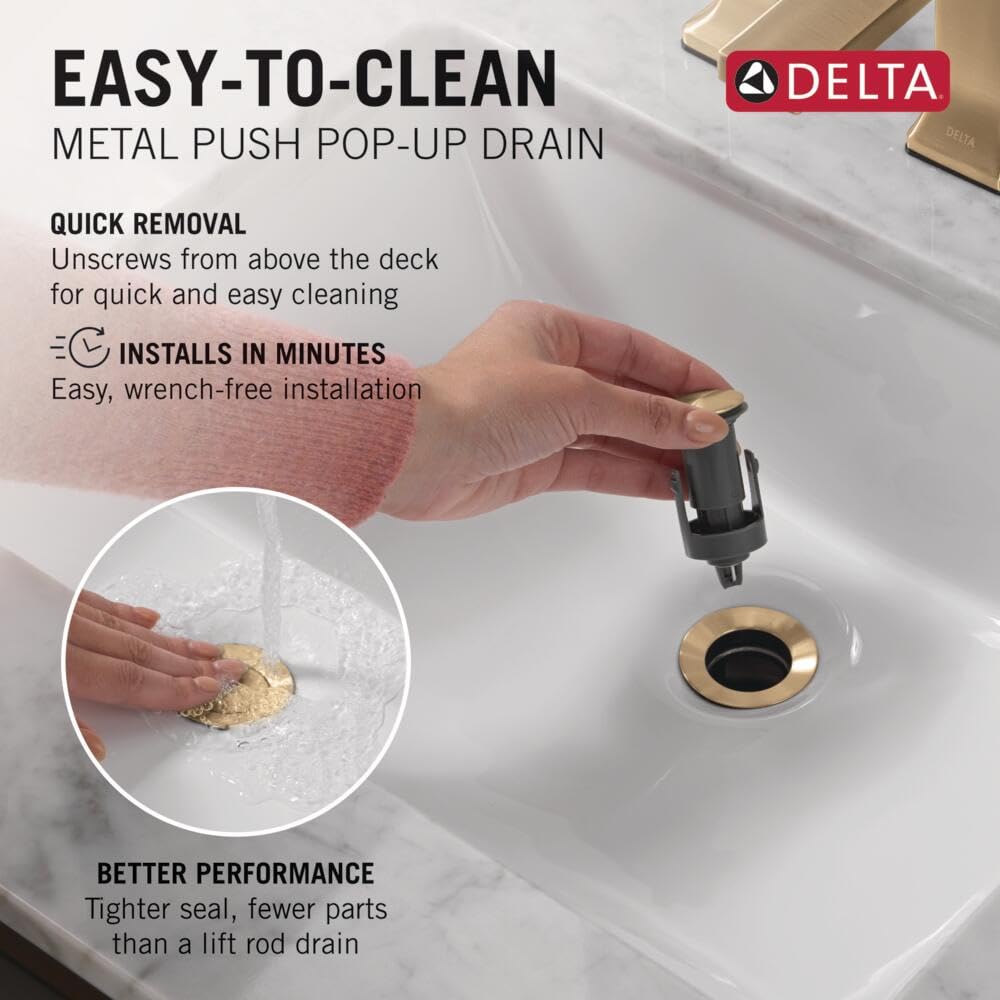 Champagne bronze push pop-up drain with black valve component being removed from white sink basin.