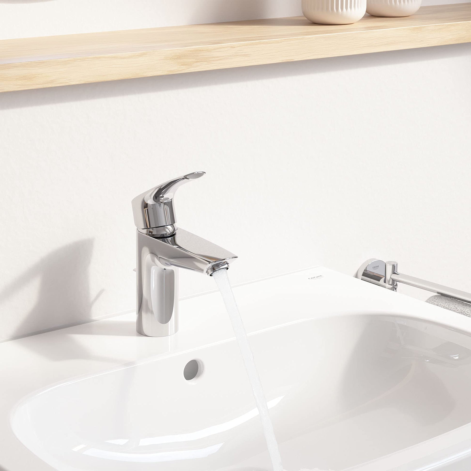 Chrome single-handle bathroom faucet with curved spout and pull-out spray mounted on white sink.