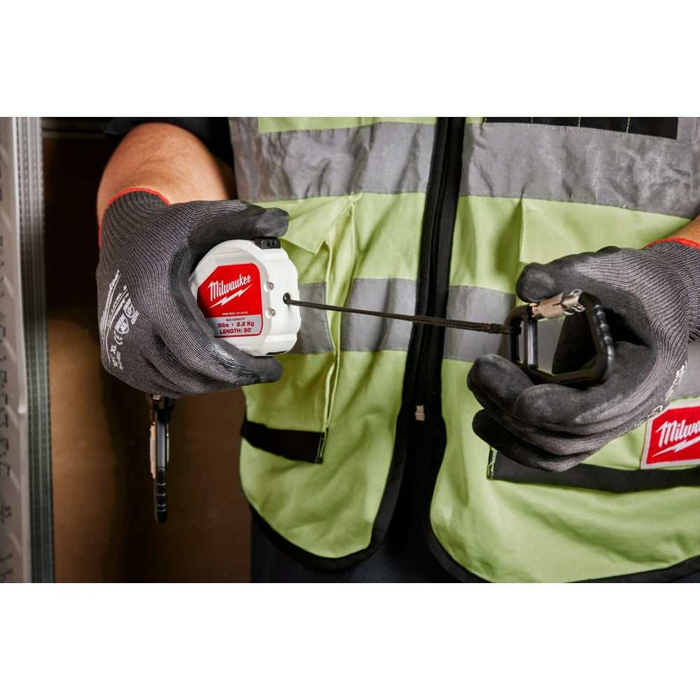 Milwaukee retractable tool lanyard with white reel and black cord held in gloved hands.