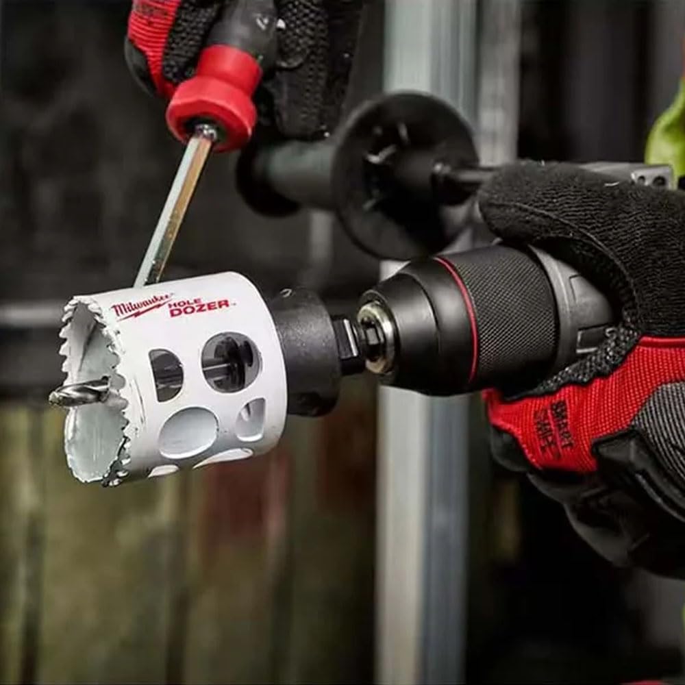 Milwaukee HOLE DOZER bi-metal hole saw with red arbor attached to power drill, cutting through metal.
