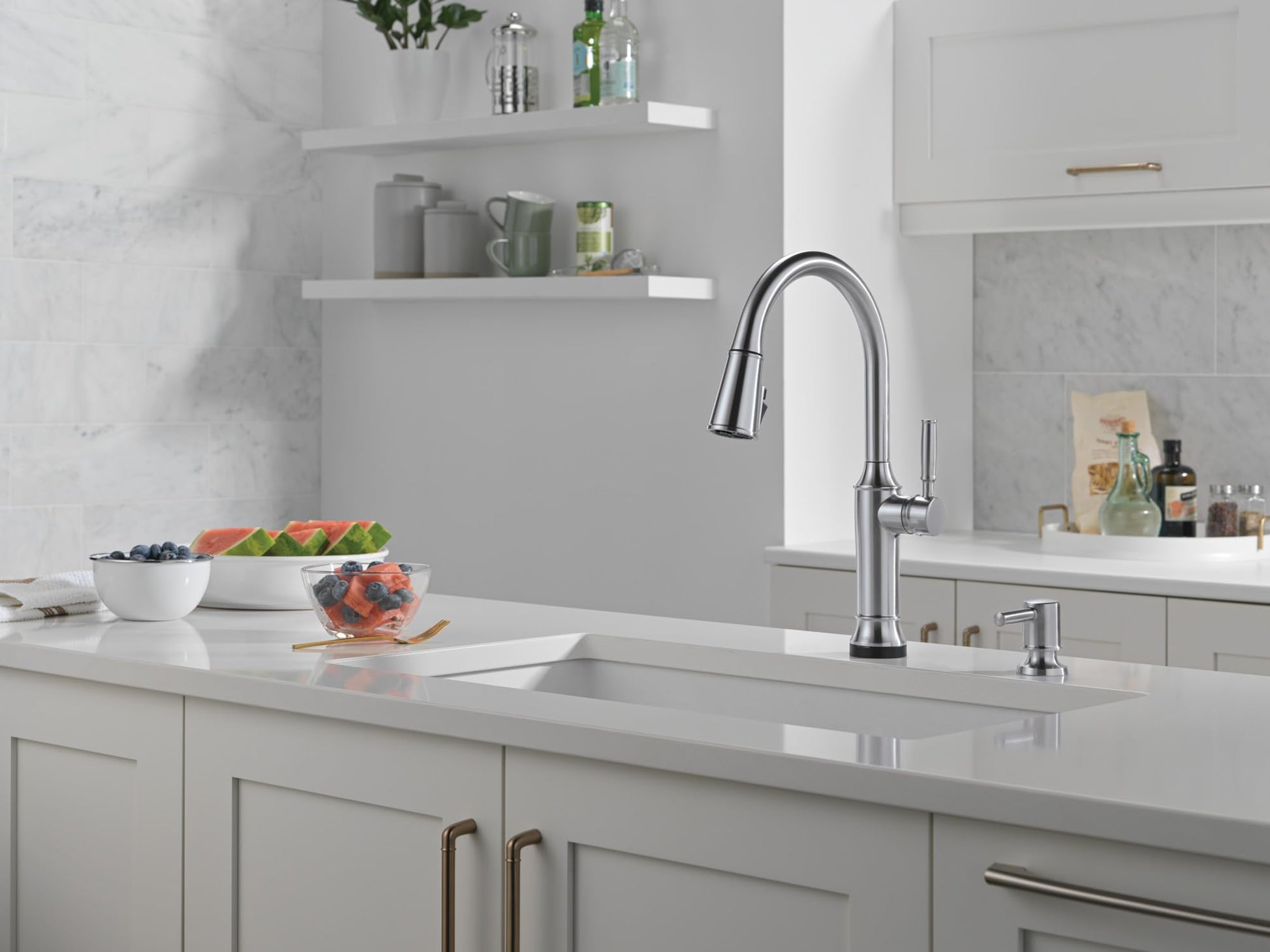Stainless steel soap dispenser with cylindrical pump head on kitchen sink counter.