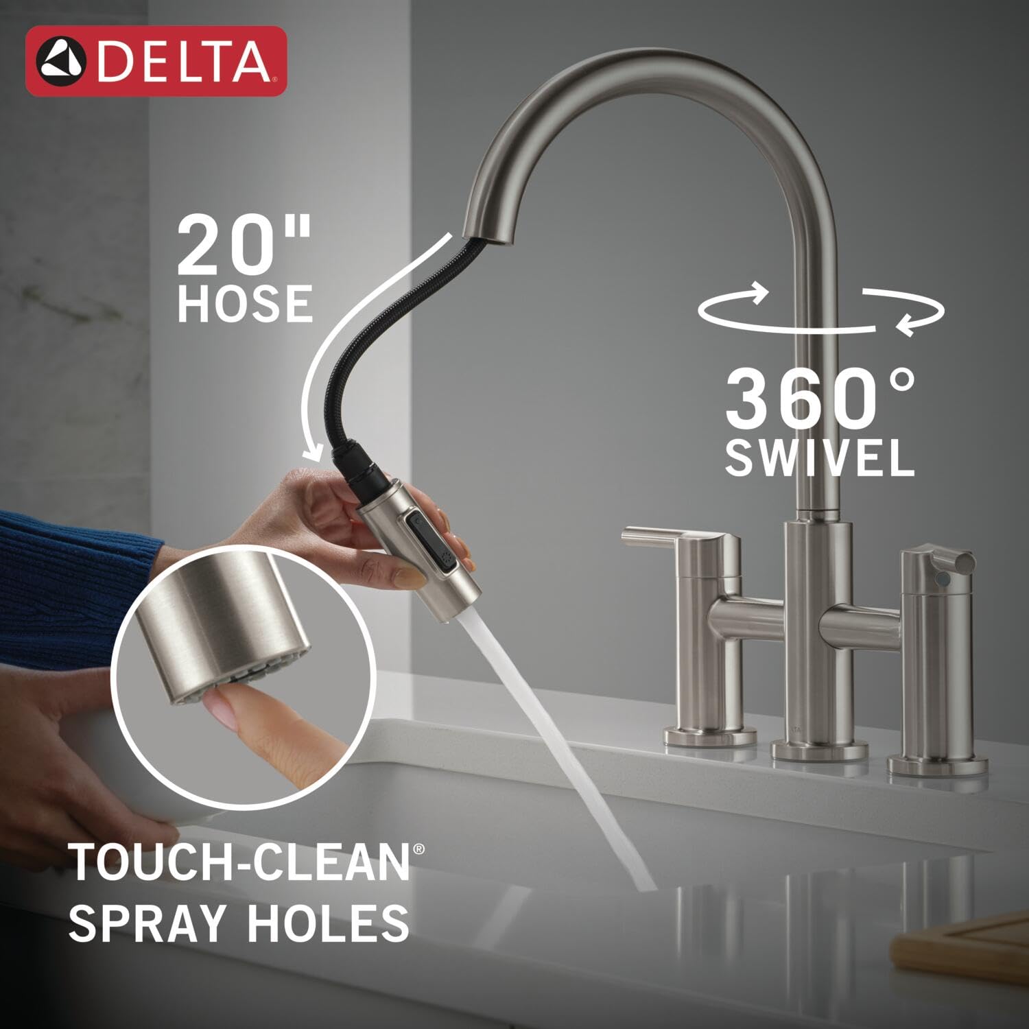 Stainless steel bridge kitchen faucet with pull-down sprayer, two handles, 360-degree swivel, and 20-inch hose.