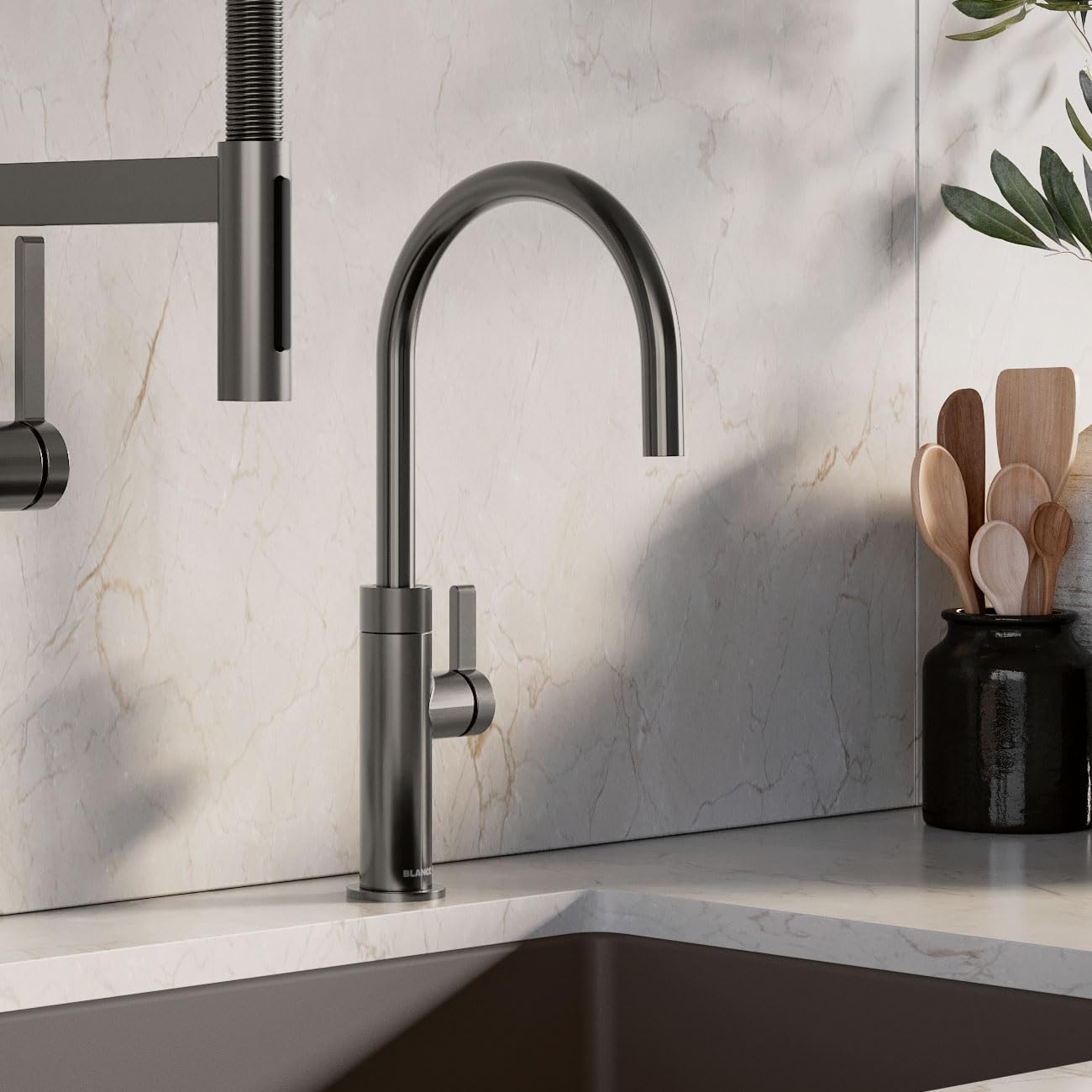 Satin dark steel beverage faucet with curved spout and side lever handle mounted on marble countertop.